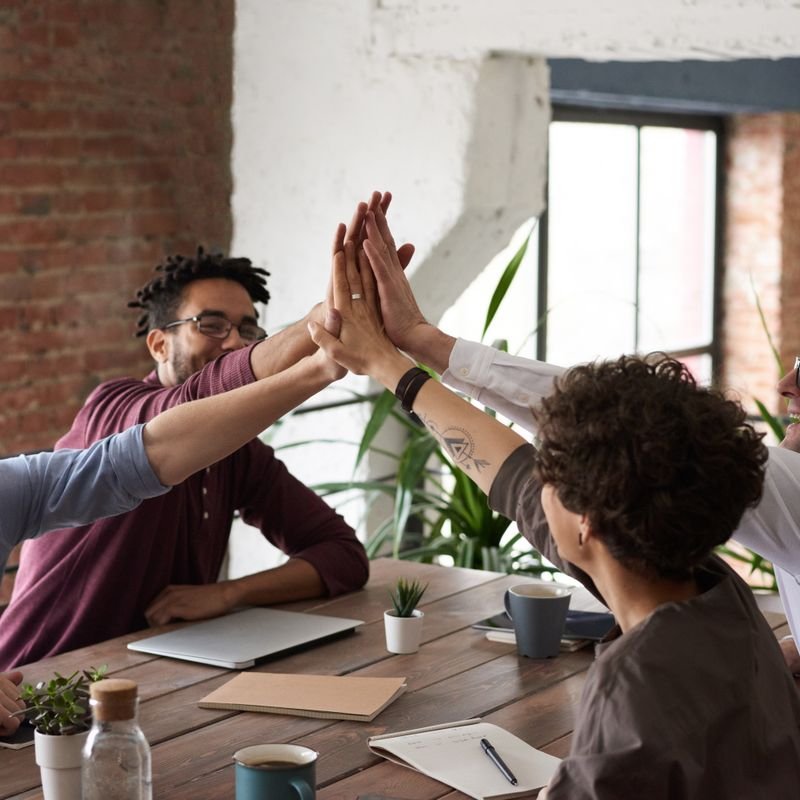 Colleagues joining hands over a table